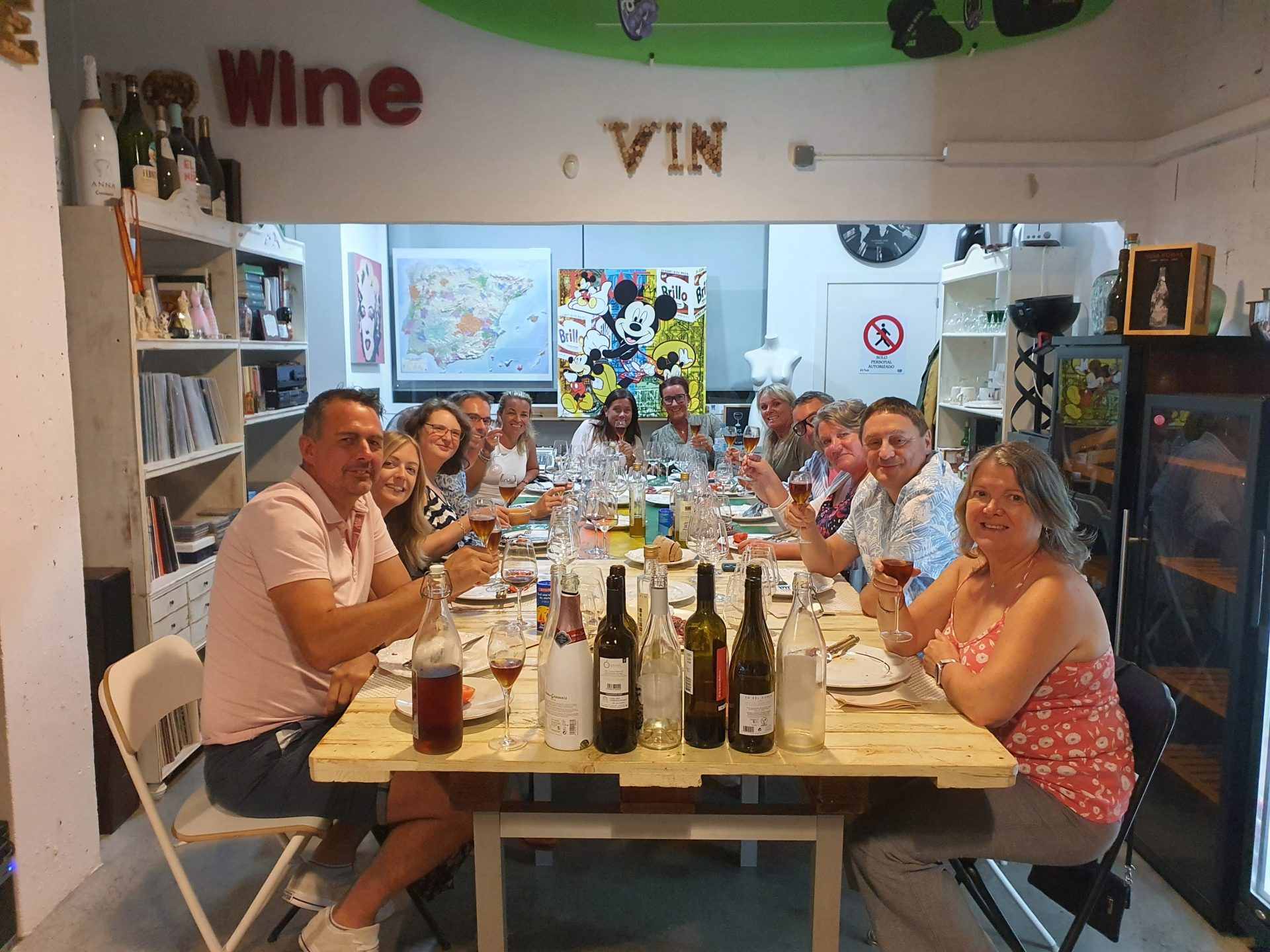 Personas sentadas a la mesa probando vino